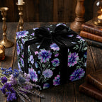 Moody floral wrapping paper with purple flowers and a black velvet bow by Wrapped Studios.