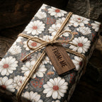 Vintage daisy floral wrapping paper on a rustic gift box with twine by Wrapped Studios.