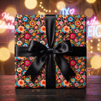 Luxury floral wrapping paper with a black satin bow on a gift box, by Wrapped Studios.