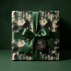 Forest green Christmas wrapping paper with a pine tree pattern and satin bow by Wrapped Studios.