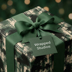Luxury forest wrapping paper on a Christmas gift box with a green ribbon by Wrapped Studios.