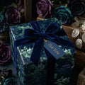 Luxury dark floral wrapping paper with a navy velvet ribbon bow by Wrapped Studios.