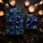 Moody floral wrapping paper with satin bows on a candlelit table, luxury gift wrap by Wrapped Studios.