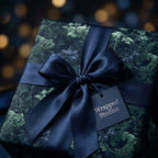 Luxury dark floral wrapping paper with a navy blue satin bow and tag by Wrapped Studios.