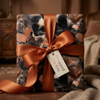 Elegant gift wrapped in black and copper watercolor heart wrapping paper with a bronze satin ribbon from Wrapped Studios.