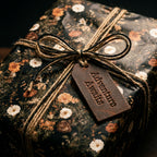 Vintage floral wrapping paper with a rustic twine bow and leather tag by Wrapped Studios.