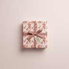 Elegant pink floral wrapping paper with a brown ribbon and gift tag, perfect for luxury birthday or wedding gifts.
