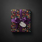 Gift box with floral pattern wrapping paper, purple ribbon, and "For You" tag on black.