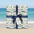 Nautical wrapping paper featuring blue fish illustrations with a navy ribbon and "A Catch for You" gift tag.