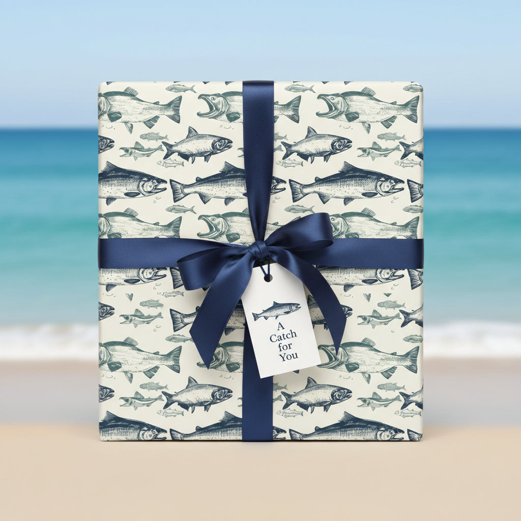 Nautical wrapping paper featuring blue fish illustrations with a navy ribbon and "A Catch for You" gift tag.