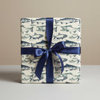 Gift wrapped in fish-patterned wrapping paper with a blue satin ribbon.