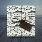 Square gift wrapped in novelty fish wrapping paper with twine bow and leather tag.