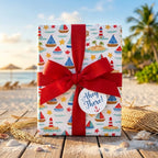 Nautical wrapping paper with sailboats and lighthouses, tied with a red bow on the beach. By Wrapped Studios.