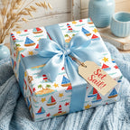 Nautical wrapping paper with cute sailboats and blue bow for baby shower gifts, by Wrapped Studios.
