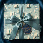Nautical gift wrap with sailboat pattern, blue ribbon, and "For the Captain" tag.