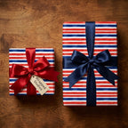 Patriotic red white and blue striped wrapping paper with satin bows on wood background by Wrapped Studios.