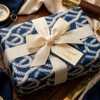 Luxury nautical wrapping paper in navy blue rope pattern with a cream bow and gift tag by Wrapped Studios.