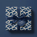 Nautical rope wrapping paper in navy blue with a matching satin bow by Wrapped Studios.