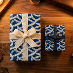 Nautical rope gift wrap in navy blue on two present boxes with burlap and twine bows by Wrapped Studios.