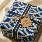 Navy blue nautical rope wrapping paper on a birthday gift with ship wheel tag by Wrapped Studios.
