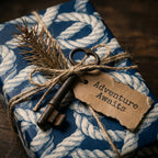 Navy blue nautical wrapping paper with rope print, rustic key, and gift tag by Wrapped Studios.