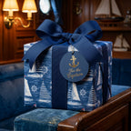 Nautical sailboat wrapping paper with a navy blue ribbon and gold anchor gift tag by Wrapped Studios.