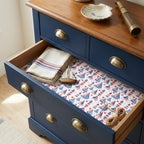 Nautical wrapping paper with sailboats used as a drawer liner in a navy dresser by Wrapped Studios.