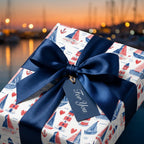 Nautical sailboat wrapping paper with a navy blue satin bow and gift tag from Wrapped Studios.