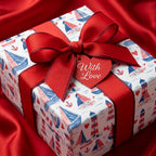 Nautical sailboat and lighthouse wrapping paper with a red bow and heart tag, by Wrapped Studios.