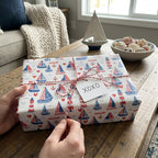 Nautical sailboat wrapping paper with red and blue lighthouses on a gift, by Wrapped Studios.