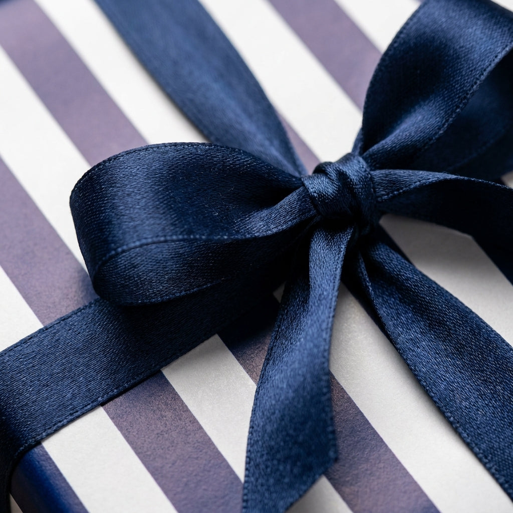Navy blue and white striped wrapping paper with a luxury satin bow by Wrapped Studios.
