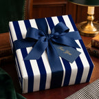 Elegant navy blue striped wrapping paper on a gift box with a luxury ribbon, by Wrapped Studios.