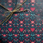 Gift box with heart pattern and gold ribbon on a matching background