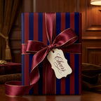 Navy and burgundy striped gift wrap with a luxury satin ribbon bow by Wrapped Studios.
