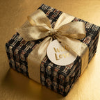 Elegant gift wrapped in nutcracker-patterned Christmas wrapping paper with a gold ribbon and "With Love" tag.