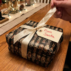 Christmas gift wrapped in nutcracker wrapping paper with ivory ribbon & "From Santa" tag.