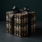 Luxury nutcracker Christmas wrapping paper on a gift box with a black satin bow by Wrapped Studios.