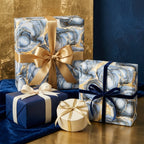 Luxury blue and gold marble wrapping paper with elegant ribbons on gift boxes by Wrapped Studios.