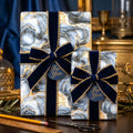 Luxury blue and gold marble wrapping paper with navy velvet bows by Wrapped Studios.