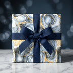 Luxury blue and gold marble wrapping paper with a navy bow by Wrapped Studios.