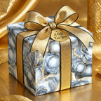 Elegant blue and gold marble wrapping paper on a gift box with a gold satin ribbon, by Wrapped Studios.