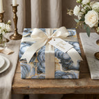 Luxury blue and gold marble wrapping paper with a cream satin bow by Wrapped Studios.