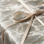 Luxury water ripple wrapping paper in neutral grey with a satin ribbon bow by Wrapped Studios.