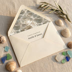 Coastal wedding invitation with ocean water envelope liner, beach sea glass, and shells, by Wrapped Studios.