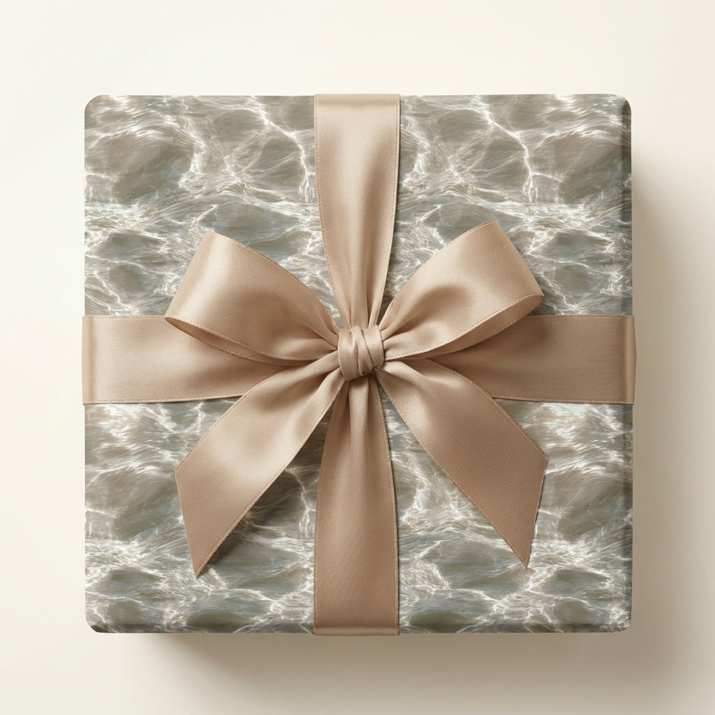 Elegant water ripple luxury gift wrap with a champagne satin bow by Wrapped Studios.