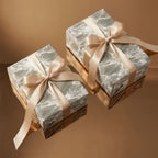 Luxury sage green water ripple wrapping paper with champagne satin bows by Wrapped Studios.