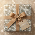Luxury water ripple wrapping paper with a gold ribbon and summer gift tag by Wrapped Studios.