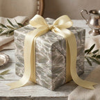Luxury sage green marble gift wrap with a cream satin bow on a wedding gift box by Wrapped Studios.