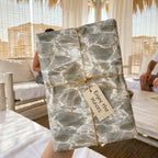 Luxury ocean wave wrapping paper with twine bow and gift tag by Wrapped Studios.