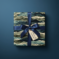 Gift wrapped in wave-patterned paper with a navy ribbon and "A Wave of Gratitude" tag, set against a matching navy background.